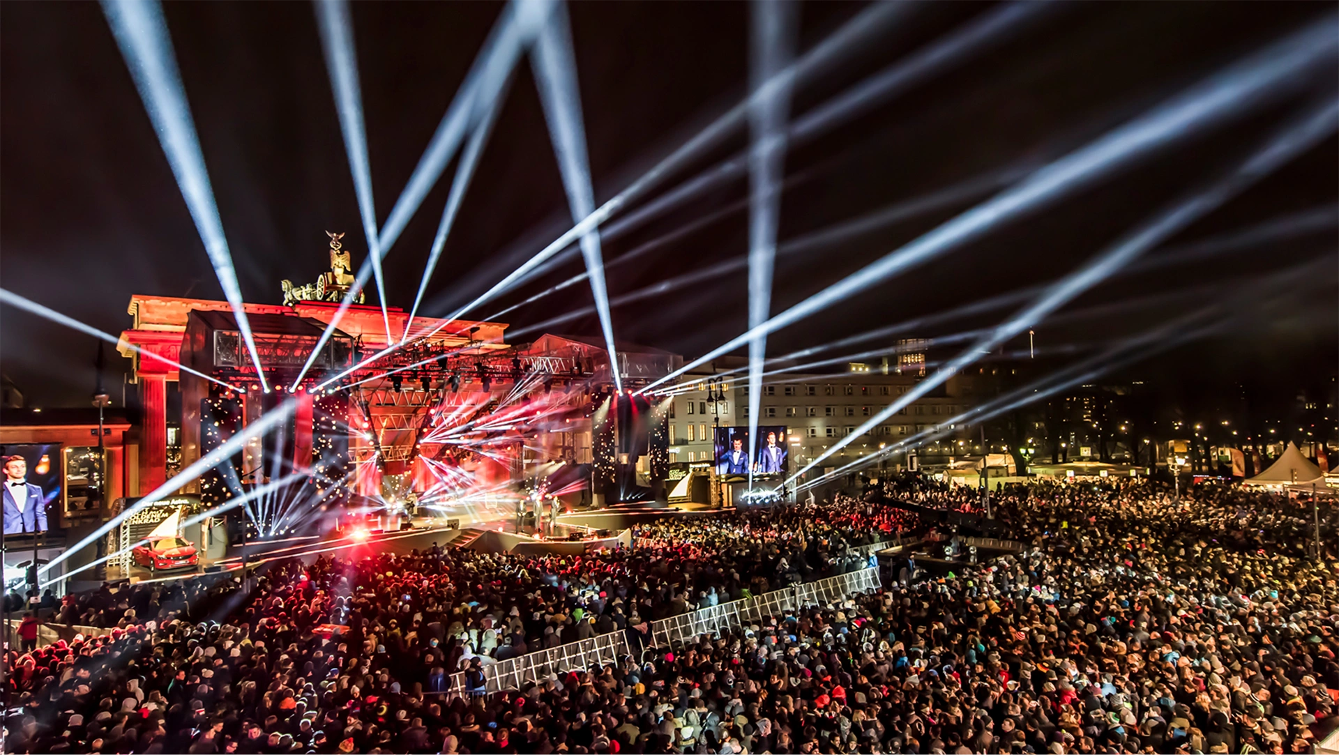 Ein Bild zeigt Personen und die Bühne beim feiern der größten organsierten Silvester Veranstaltung der Welt, Silvester Berlin.