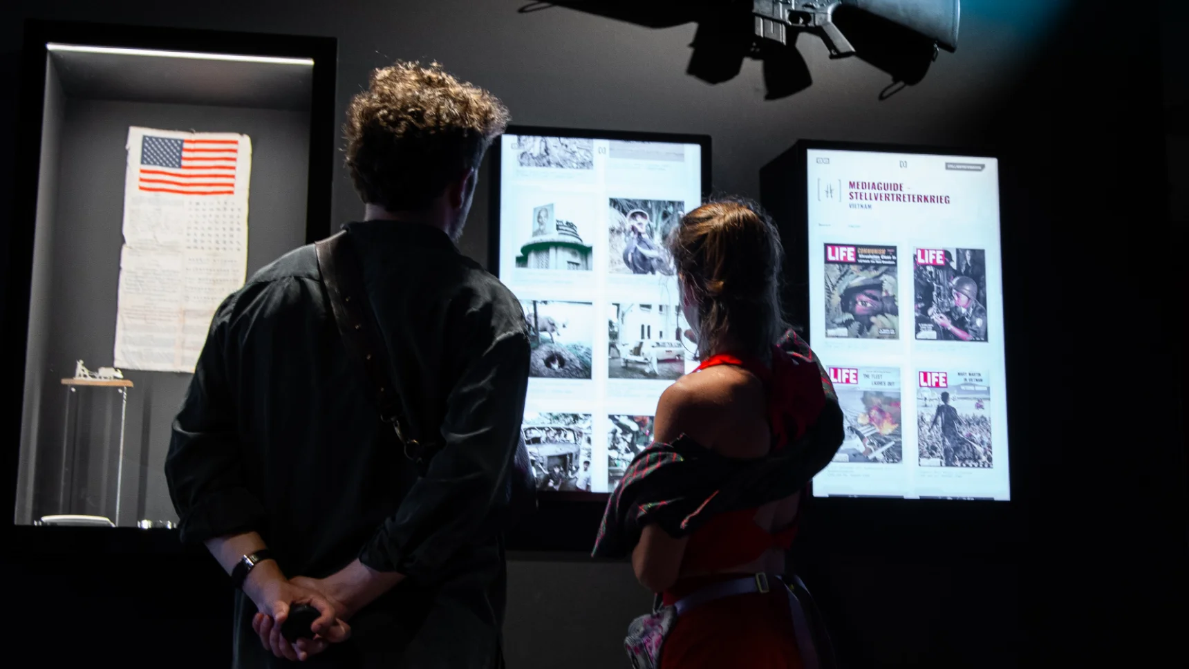 One picture shows two people in front of two screens with information about the Cold War.