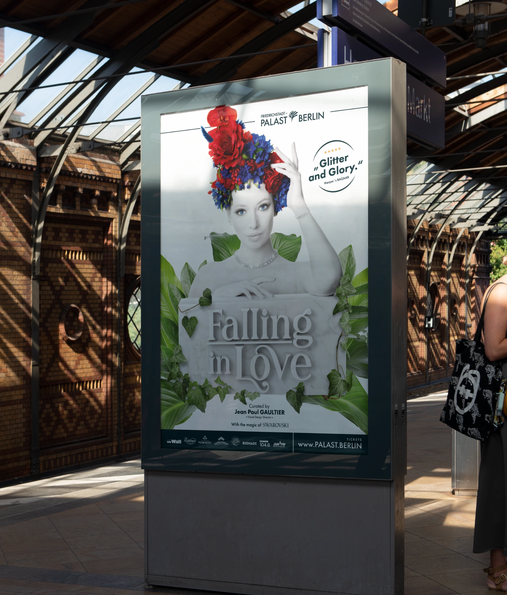 One picture shows a poster of the Friedrichstadtpalast Berlin Grand Show "Falling in Love" at a train station.