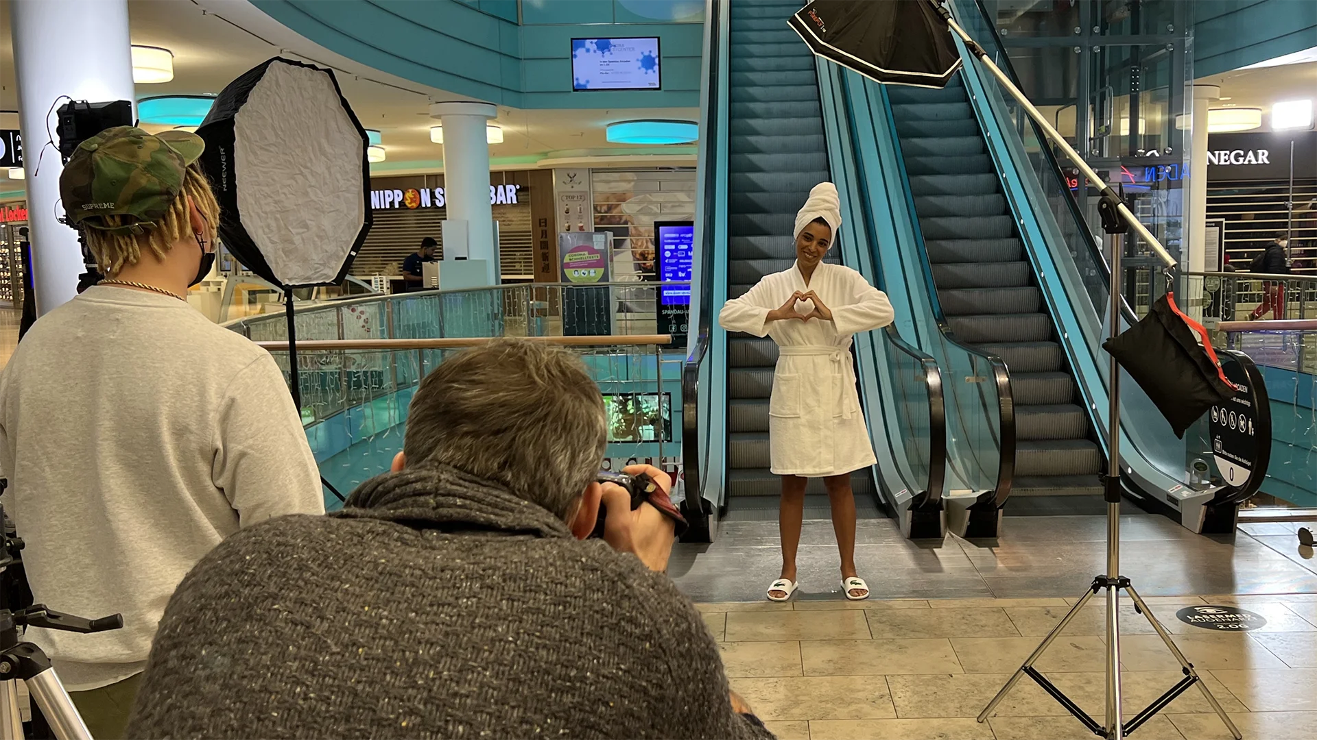 A picture shows a woman in a bathrobe in front of the escalators in the Spandauer Arcaden shopping center in Berlin.