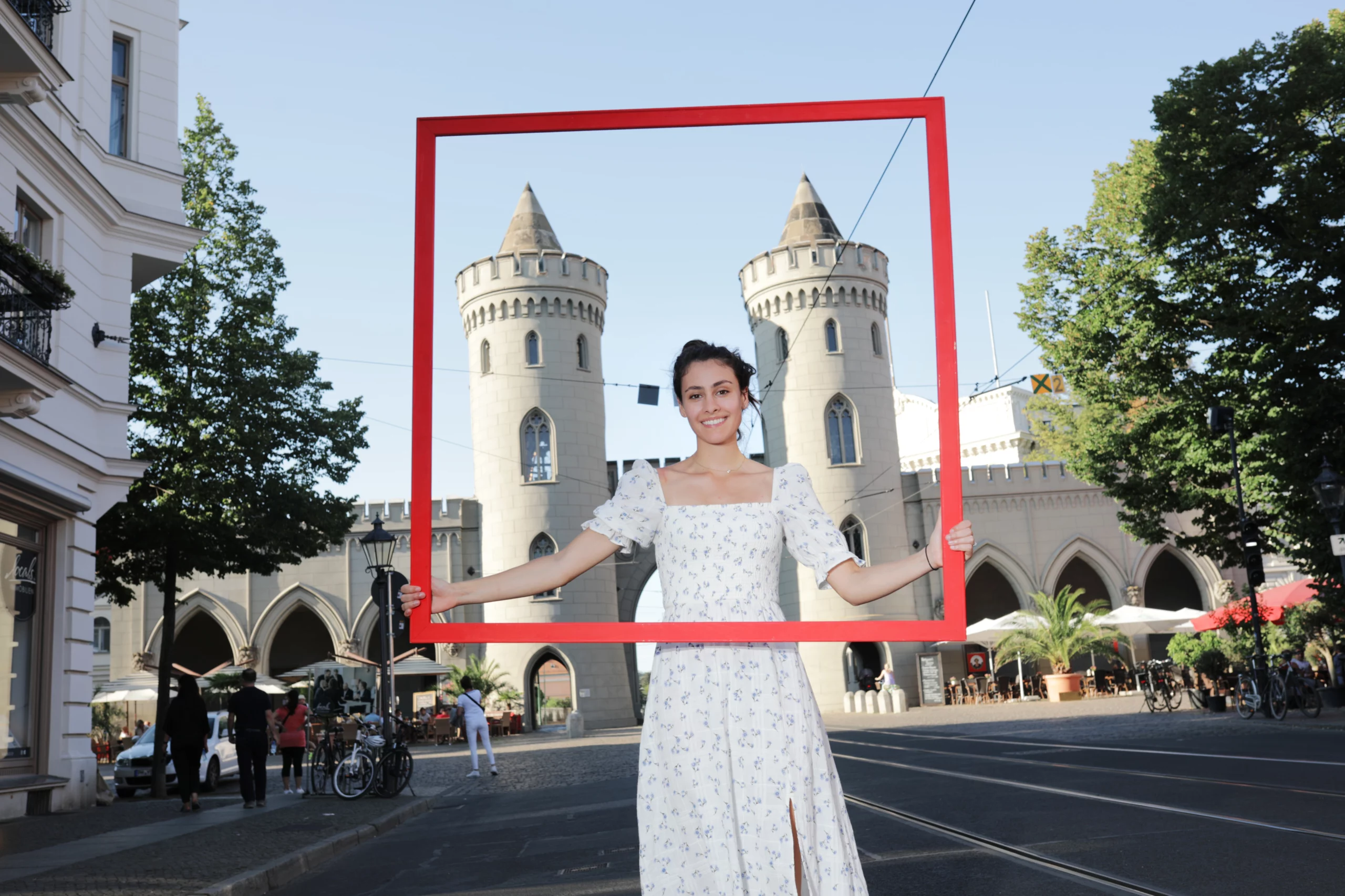 One picture shows a young woman in a red picture frame on the Day of German Unity in Berlin.